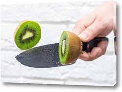    Floating knife slicing trough kiwi fruit.