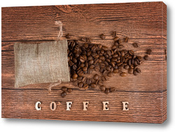    Black coffee foil packaging bag on wooden table top view. Spilled beans flat lay concept. Room for text.